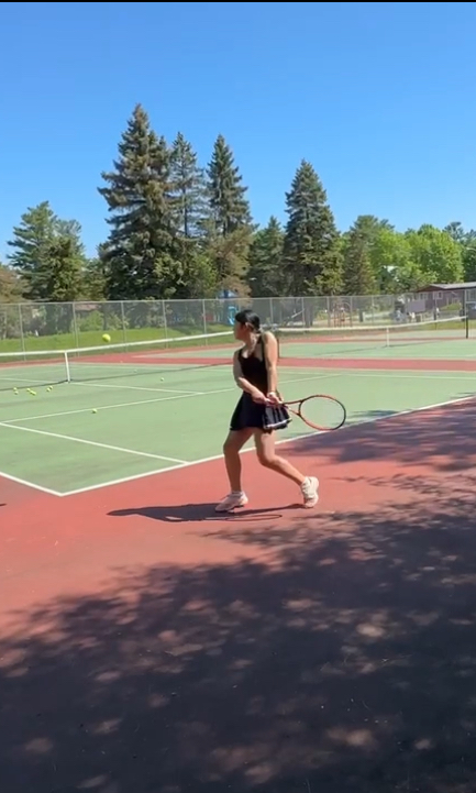 Chenyi playing tennis on an outdoor court