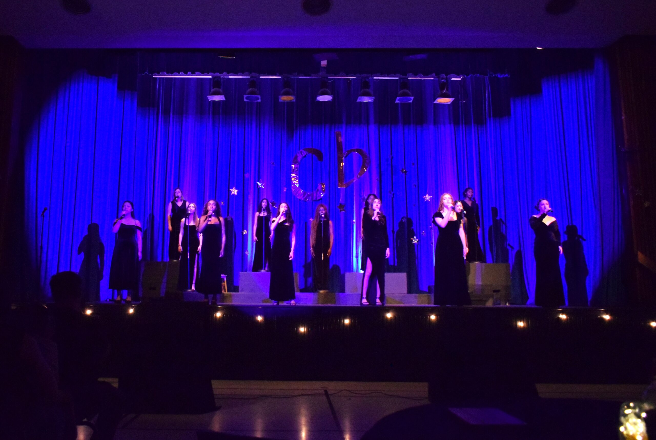 Blessing performing with a small vocal group on stage